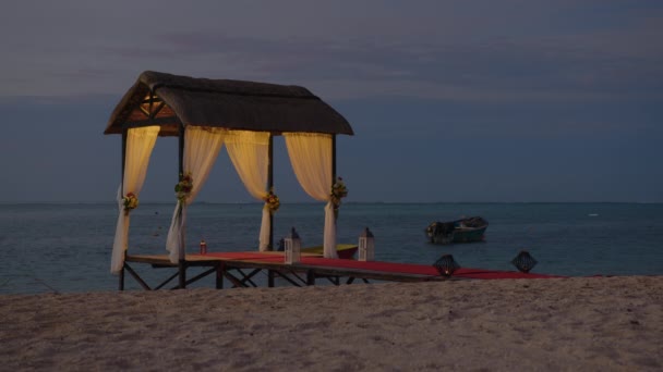 Playa nupcial preparada para la playa. Arco de boda en la orilla del Océano Índico decorado con flores. Concepto de vacaciones. Boda patrones de eventos isla al atardecer — Vídeos de Stock