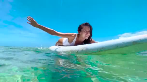 A rapariga nada numa prancha de surf. Uma rapariga bonita está a surfar. Movimento lento — Vídeo de Stock