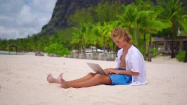 Bir öğrenci, turkuaz suyun arka planında oturarak kendini eğitmekle meşgul. Çevrimiçi eğitim kavramı. COVID-19 tecridi sırasında online derse katılan genç bir çocuk.