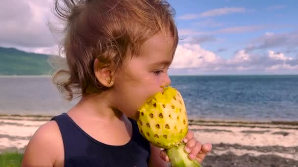 Un pequeño bebé come una jugosa y deliciosa piña en el fondo del mar — Vídeo de stock