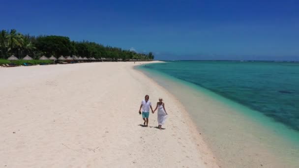 Молодая пара, идущая и держащаяся за руки на пляже. Здоровое времяпровождение на открытом воздухе у тропического моря. Воздушные путешествия. Мальдивы. — стоковое видео