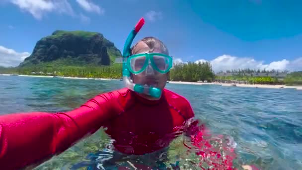 Een selfie onder water geschoten door een blanke man met een lichaamsbouw drijft prachtig onder water. Het concept van gratis duiken en recreatie aan de zeekust of op de oceaan — Stockvideo