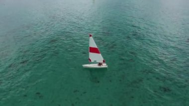 Denizde bir yelkenli yatının havada vurulması. Denizde güneşli bir gün. Hint Okyanusu 'nda yatla giden bir adam.