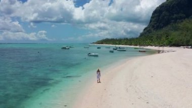 Mauritius Hint Okyanusu 'ndaki tropikal bir adada beyaz bir kumsalda yürüyen bir kız.