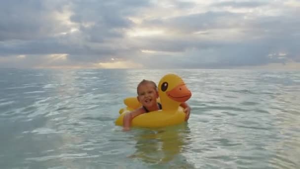 愛らしいです女の子水泳とともにインフレータブルアヒルでインド洋 — ストック動画