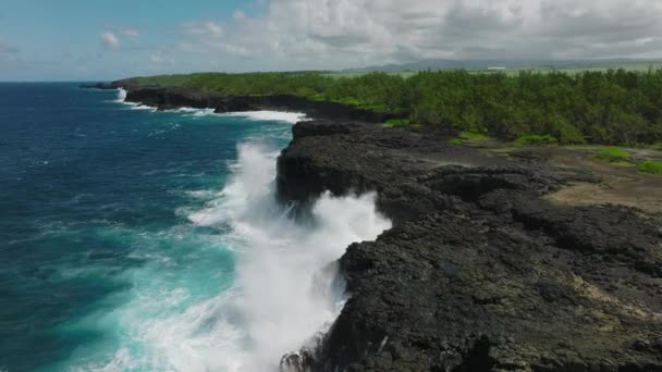 Dalgaların açık mavi sularla kayalık bir sahildeki hava görüntüleri. — Stok video