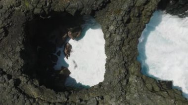 Pont Naturel. Mauritius. Dalgaların yukarıdan görünüşü mavi bir okyanusta kayalara çarpıyor..