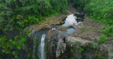 Büyük bir şelalenin tepesinde büyük bir aile. Aile seyahati kavramı. Hava görünümü