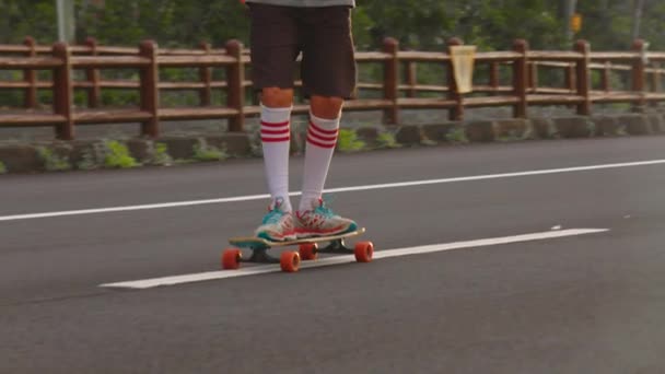Menino retrato com um longboard em uma bela estrada. Adolescente skate nas ruas da cidade — Vídeo de Stock