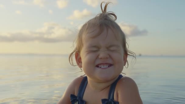 A little girl in the Sea of Azov in Mariupol smiles and grimaces. Close up portrait little baby of Ukraine — Stockvideo