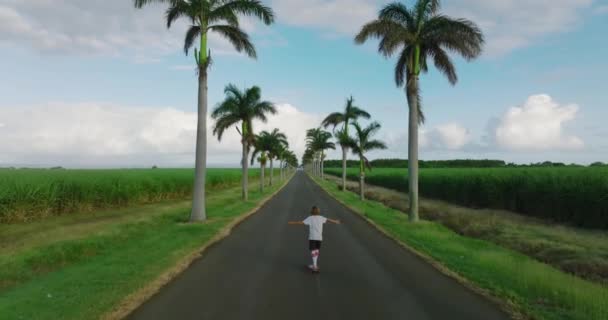 Portrait boy with a longboard on a beautiful road. Teenager skateboarding on city streets — Stock Video