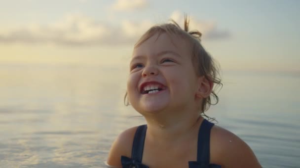 マリウポリのアゾフ海の小さな女の子は笑顔と優雅さ。ウクライナの肖像画の小さな赤ちゃんを閉じます — ストック動画