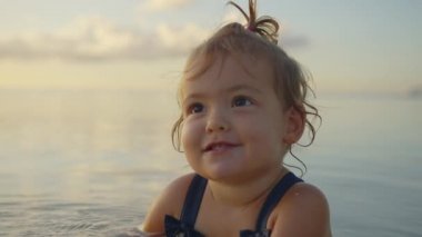 Mariupol 'de Azov Denizi' nde küçük bir kız gülümsüyor ve surat asıyor. Yakın plan Ukrayna 'nın küçük bebeği