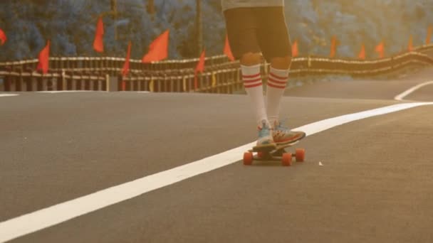 Portræt dreng med en longboard på en smuk vej. Teenager skateboarding på byens gader – Stock-video