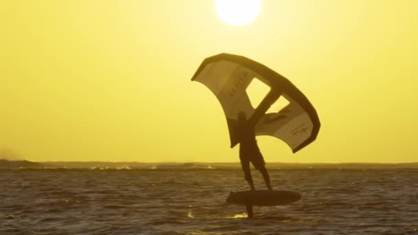 Le jeune kiteboarder surfant à Maurice saute en parcourant le lagon turquoise. Kitesurfer éclabousse l'eau de mer vitreuse tout en chevauchant à Maurice — Video