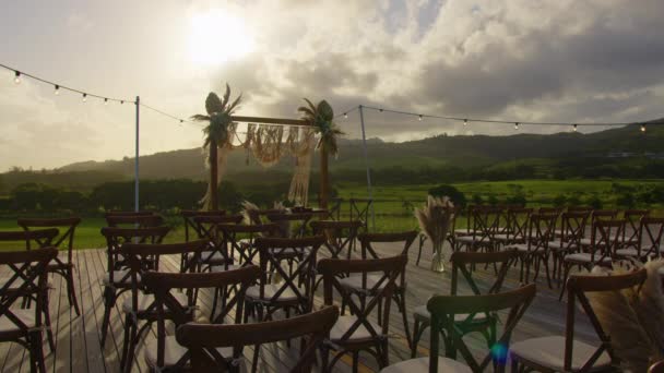 Mooie Boheemse tipi boog decoratie op outdoor huwelijksceremonie locatie. Stoelen, bloemige bloemcomposities van rozen, tapijt, string fee lichten. Zomer landelijke bruiloft. — Stockvideo