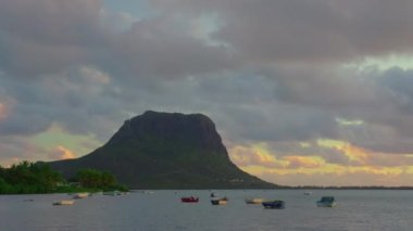 Hint okyanusu ve günbatımı bulutlarıyla Mauritius 'un dağlık manzarasının zamanı. Bulutların oluşumu ve hareketleri. Le Morne dağında bulutların hareketi. Yüksek kalite 4k görüntü