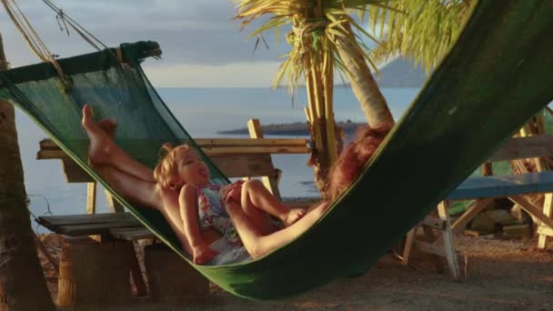 Genç Anne Kızıyla Birlikte Kumsalda Oturmuş Gün Batımının Arka Planına — Stok video