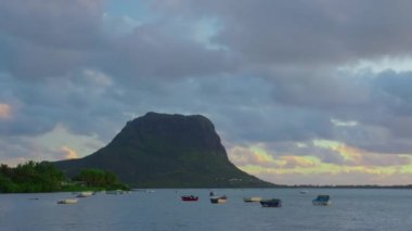 Hint okyanusu ve günbatımı bulutlarıyla Mauritius 'un dağlık manzarasının zamanı. Bulutların oluşumu ve hareketleri. Le Morne dağında bulutların hareketi. Yüksek kalite 4k görüntü