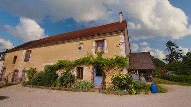 Paris yakınlarındaki Provence 'de Fransız sabahı. Beyaz elbiseli bir kız bir fincan kahve ve bir kruvasanla eski bir Fransız evinin eşiğinde yürüyor. Yüksek kalite 4k görüntü