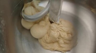 Çökme Hamuru. Baker hamur karıştırıcısında ekmek için hamur hazırlıyor. Fırın ürünleri üretimi. Fırıncı hamur ürünleri yapıyor. Yüksek kalite 4k görüntü