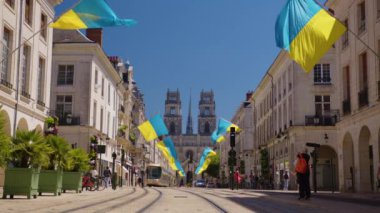 Orleans, Fransa, 12 Temmuz 2022: Fransa 'nın Orleans şehrinde büyük Ukrayna bayrakları dalgalanıyor. Fransa 'nın merkez caddesinde birçok Ukrayna bayrağı var. Orleans 'ın merkezinde insanlar sokakta yürüyor..