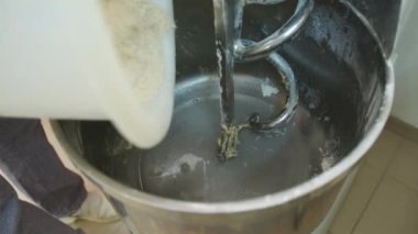 Kneading Dough. Baker preparing the dough for bread in a dough mixer. Manufacture of bakery products. The baker is making dough products. High quality 4k footage