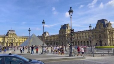 Paris, France, 28 July 2022: Famous Louvre museum. A lot of tourists walk along the famous square in Paris. High quality 4k footage