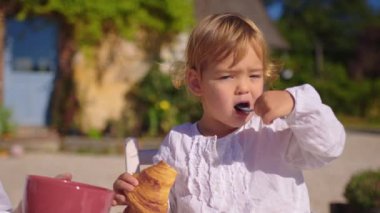 Baby eat croissants on a summer morning in France. Concept of making breakfast at home. French traditional breakfast coffee with croissant. High quality 4k footage