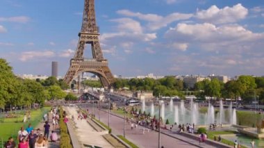 Timelapse, movement of clouds. People walk in Paris with the Eiffel Tower in the background. The most popular tourist attraction in the world. Paris, France. High quality 4k footage