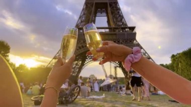 Beautiful happy lesbian couple celebrate wedding at an evening in front of the Eiffel Tower in Paris. Love couple with glasses of champagne in a romantic place. Lgbt love. High quality 4k footage