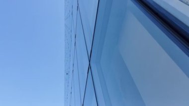 Building reflected on glass skyscraper in Paris, grey skyscraper in Paris, open glass at left, blue sky and reflections. Wide Shot. High quality 4k footage