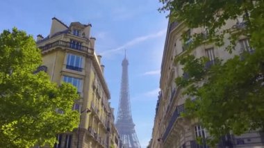 Eiffel Tower on Champs de Mars in Paris, France. Blue cloudy sky at summer day with green lawn. High quality 4k footage