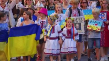 Paris, France, August 24 2022: People protesting against war, crowd waving flags. View of Ukrainian people protest on the streets of Paris against the war, people with flags. Independence Day.