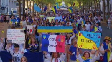 Paris, France, August 24 2022: People protesting against war, crowd waving flags. View of Ukrainian people protest on the streets of Paris against the war, people with flags. Independence Day.