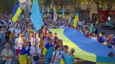 Paris, France, August 24 2022: People protesting against war, crowd waving flags. View of Ukrainian people protest on the streets of Paris against the war, people with flags. Independence Day.
