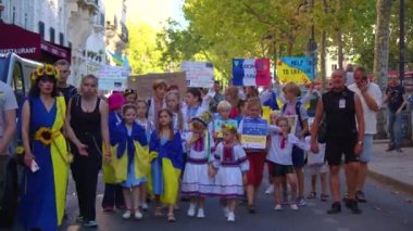 Paris, France, August 24 2022: People protesting against war, crowd waving flags. View of Ukrainian people protest on the streets of Paris against the war, people with flags. Independence Day.