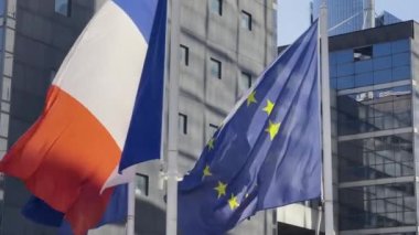 France and EU flag on flagpole excellent quality. French Republic and The European Union waving flag in wind background building glass skyscraper in Paris. High quality 4k footage