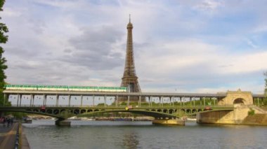 Iron bridge over the river in Paris near the metal tower on which the Paris metro passes. Metro train over Bir-Hakeim bridge and the Eiffel Tower. High quality 4k