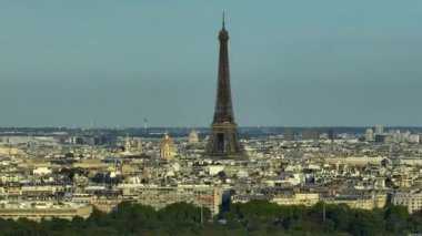 Parallax effect. Close-up shot of the Eiffel tower on a drone from a height. Aerial Panorama of Paris Cityscape. Landmark French Monument in Historic City Center. Most Visited Travel European City.