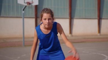 The teenager plays basketball. Healthy lifestyle and hobby concept. Cute kid hitting a basketball ball. Slow motion street basketball. Boy practicing shooting a basketball. High quality 4k footage