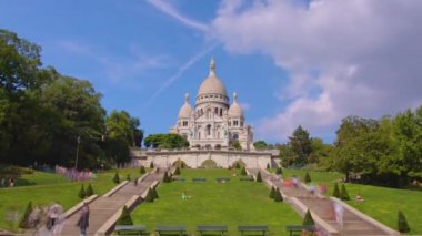 Tourists near the Basilica of the Sacred Heart of Paris Sacre-Coeur is a Roman Catholic church timelapse. Located at the summit of the butte Montmartre. Paris, France. High quality 4k footage