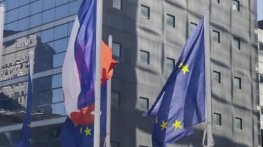 France and EU flag on flagpole excellent quality. French Republic and The European Union waving flag in wind background building glass skyscraper in Paris. High quality 4k footage