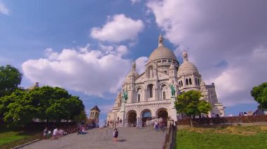 Tourists near the Basilica of the Sacred Heart of Paris Sacre-Coeur is a Roman Catholic church timelapse. Located at the summit of the butte Montmartre. Paris, France. High quality 4k footage