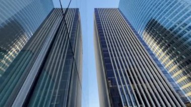Building reflected on glass skyscraper in Paris, grey skyscraper in Paris, open glass at left, blue sky and reflections. Wide Shot. High quality 4k footage