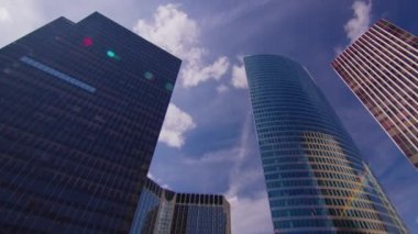 Timelapse. Skyscrapers modern business and financial district in Paris with high rise buildings and convention center. Blue cloudy sky in summer day. Reflections. High quality 4k footage