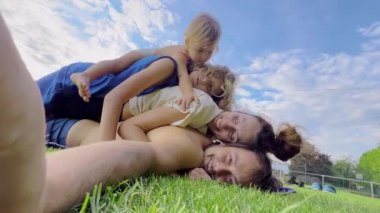 Anne, baba ve iki çocuk da dahil olmak üzere mutlu bir aile, yaz tatilini bahçede ya da parkta geçiriyor. Gülümseyen ebeveynler ve çocuklar birlikte boş zaman geçiriyorlar. Yüksek kalite 4k görüntü