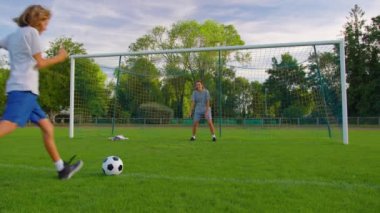 Kadın futbolcu oğluyla futbol oynuyor. Parkta eğlenen mutlu bir aile. Yüksek kalite 4k görüntü