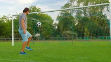 Top Sporcu 'nun kontrolünde. Futbol topu olan çocuk. Çocuk futbol topuyla hokkabazlık yapıyor. Çocuk futbol maçı rüyası. Parkta spor eğitimi. Çocuk top çeviriyor. Sağlıklı bir yaşam tarzı. Yüksek kalite 4k görüntü