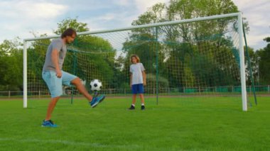 Top Sporcu 'nun kontrolünde. Futbol topu olan çocuk. Çocuk futbol topuyla hokkabazlık yapıyor. Çocuk futbol maçı rüyası. Parkta spor eğitimi. Çocuk top çeviriyor. Sağlıklı bir yaşam tarzı. Yüksek kalite 4k görüntü